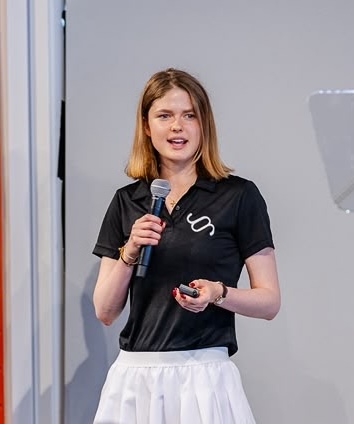 Erin speaking into a microphone at Demo Day