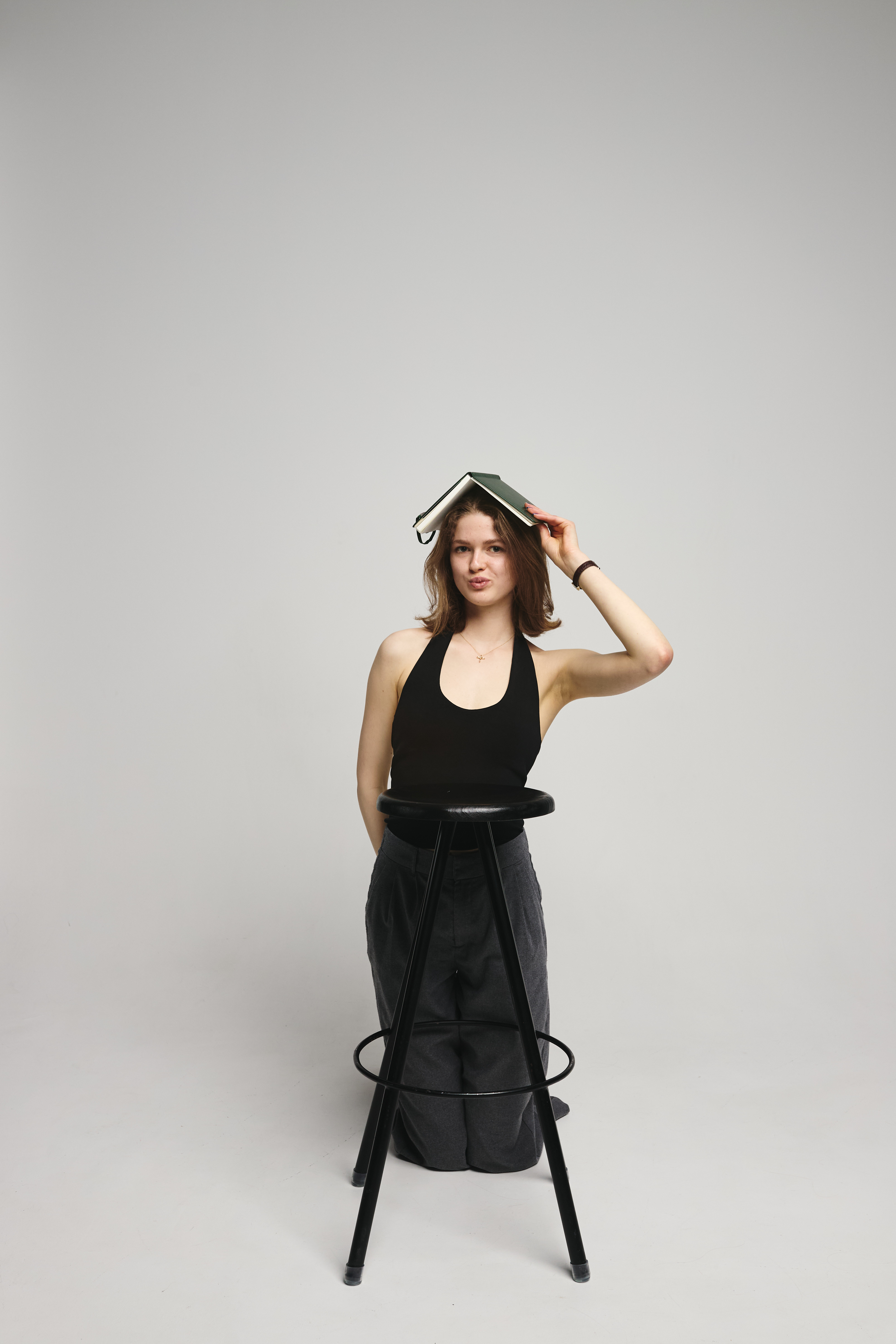 Erin standing behind a stool with an open book on her head